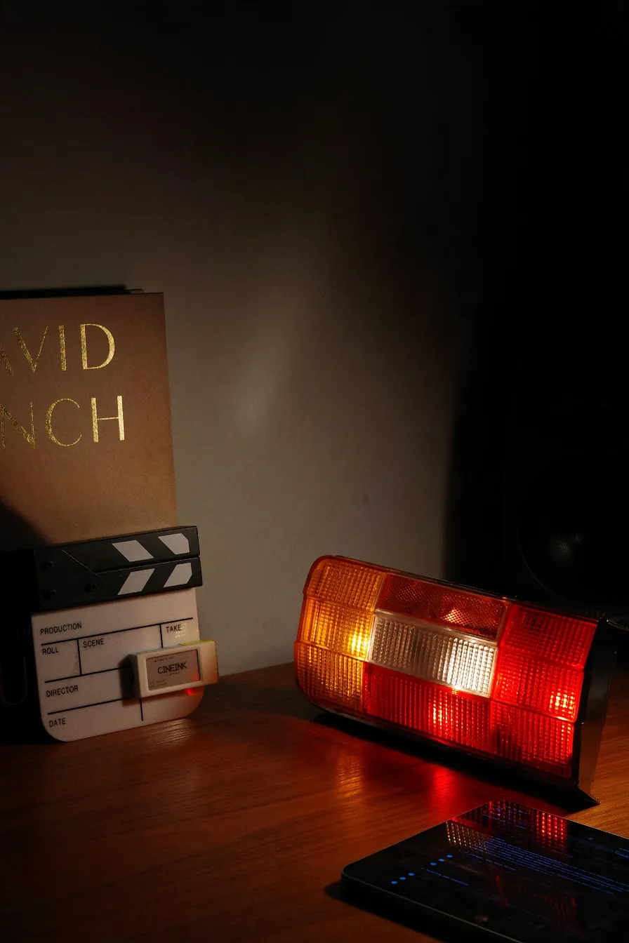 The tail light on a desk next to a film slate and a studio monitor