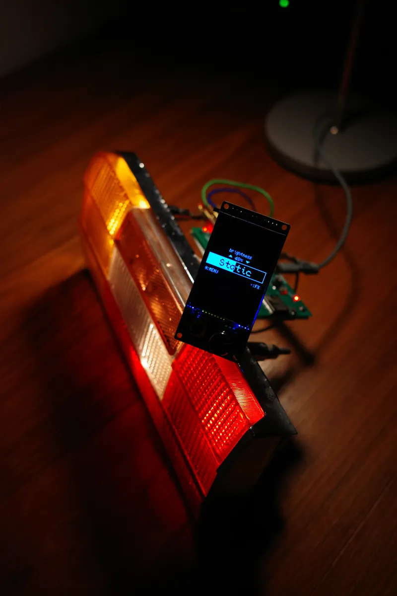 The tail light with a 2.4-inch TFT module and a rotary encoder showing the main screen